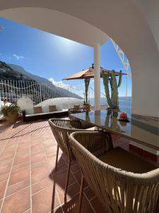 eine Terrasse mit einem Tisch und Stühlen auf dem Balkon in der Unterkunft Casa Positano in Positano