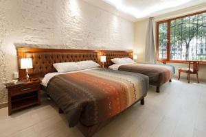 基多艺术广场民宿的一间有两张床和一扇窗户的酒店房间