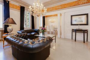 a living room with a leather couch and a chandelier at Casa San Domenico in Mantova