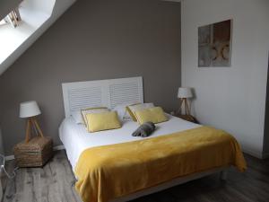 a bedroom with a bed with yellow sheets and two lamps at Gîte pour 2 personnes le domaine de la roquette près de fécamp à ganzeville in Ganzeville