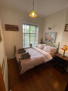 a bedroom with a large bed and a window at The Little Hideaway - Historic Gem off Haworth Main Street in Haworth