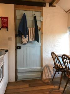 Una puerta en una cocina con mesa y sillas en Tiny Cosy Snug, en Pembrokeshire