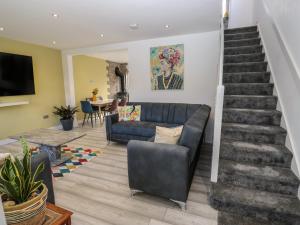 a living room with a couch and a staircase at Cosmic Pearl in Garforth