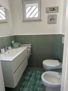 a bathroom with a sink and a toilet and a window at Villa Rita a 200m dal mare in I Bacini