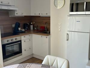 a kitchen with white appliances and a white refrigerator at Studio cocooning cap d’Agde in Cap d'Agde