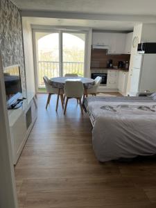 a bedroom with a table and chairs and a kitchen at Studio cocooning cap d’Agde in Cap d'Agde