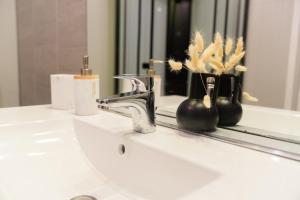 a bathroom sink with a faucet and a mirror at Les Salins * Appartement * Clim * Wifi * Commerces in Fos-sur-Mer +16 photos