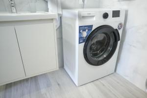 a washing machine in a bathroom next to a sink at SHANO'S Apartment - Free Parking in Sarandë
