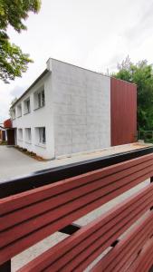 ハジコビにあるAPARTAMENTY Charzykowyの建物の前の木製のベンチの後ろの建物