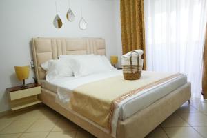 a bedroom with a large bed with a basket on it at SHANO'S Apartment - Free Parking in Sarandë