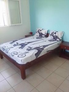Una cama en un dormitorio con una foto. en Résidence Lilas Rose, en Andilana