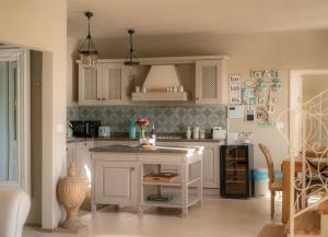 a kitchen with white cabinets and a island in it at Villa Moonlight in Poreč