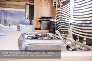 a kitchen with a sink and a stove at Strandbad Steckborn mit Herberge, Camping & Glamping in Steckborn