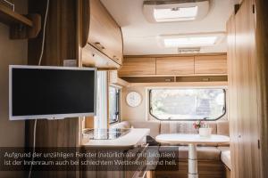 an interior view of an rv with a flat screen tv at Strandbad Steckborn mit Herberge, Camping & Glamping in Steckborn