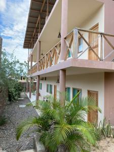 ein Gebäude mit einem Balkon und Palmen davor in der Unterkunft Casamar in Máncora