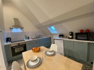 eine Küche mit einem Tisch und einer Obstschale darauf in der Unterkunft Cocon au calme en hyper centre in Château-Renault