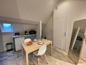 a room with a table and chairs and a kitchen at Cocon au calme en hyper centre in Château-Renault