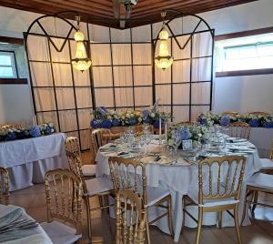 een eetkamer met tafels en stoelen met bloemen bij Solar de Almeidinha in Mangualde