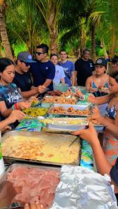 a group of people sitting around a table with food at Haranai Camping & Tours in Te-Fare-Arii