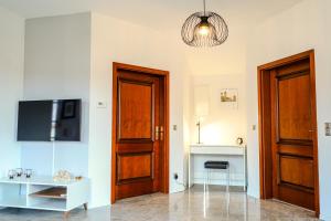 Pokój z dwoma drewnianymi drzwiami i telewizorem w obiekcie 2-Raum App mit Terrasse Jena Zöllnitz w mieście Jena