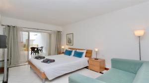 Un dormitorio con una cama, un sofá y un televisor. en Al Charb TopFloor sea view, ar con, pool - CleverDetails, en Vilamoura 40 fotos más