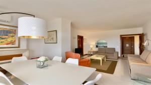 Una sala de estar con una mesa y sillas blancas. en Al Charb TopFloor sea view, ar con, pool - CleverDetails, en Vilamoura