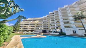 un hotel con piscina frente a un edificio en Al Charb TopFloor sea view, ar con, pool - CleverDetails, en Vilamoura