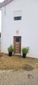 un edificio blanco con dos macetas delante de una puerta en Beautiful Casita "12min from Torres Vedras", 