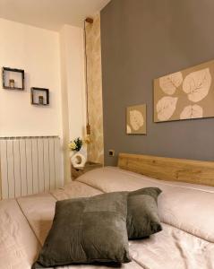 1 dormitorio con 2 camas y una pared con pinturas en Il Bollore House en Bagni San Filippo