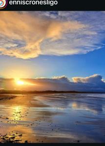 een zonsondergang op een strand met zonsondergang bij Wards in Ballina