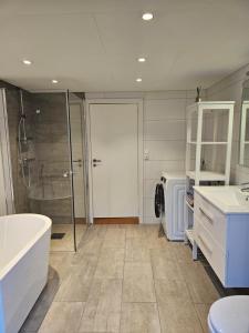 a bathroom with a tub and a shower and a toilet at Tomannsbolig sentralt Stavanger in Stavanger