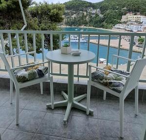 a table and chairs on a balcony with a view of the beach at Pension Hara in Patitiri