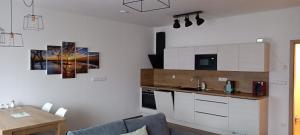a kitchen with white cabinets and a table in a room at Wellness Hotel Frymburk Apartmány in Frymburk