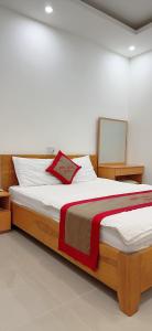 a bedroom with a large bed with white and red sheets at Hotel Minh Thắng in Vung Tau