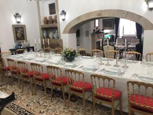 a long table with chairs and plates and wine glasses at Solar de Almeidinha in Mangualde