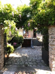 an entrance to a house with a gate with flowers at Studio La lanterne avec Jardin in Sainte-Geneviève-des-Bois