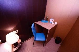 baño con una mesa pequeña y una silla azul en VIP apart 798, en Tiflis