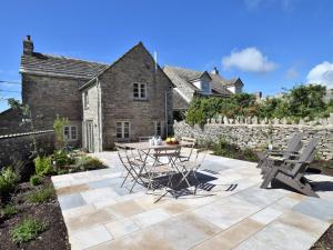 a patio with a table and chairs in front of a house at 3 Bed in Isle of Purbeck IC081 in Langton Matravers