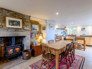 a dining room with a wooden table and a fireplace at 3 Bed in Isle of Purbeck IC081 in Langton Matravers