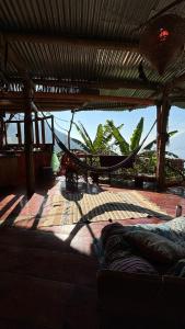 a hammock on a patio with a view of the ocean at Earthship 3 levels FAMILY cabin with lake view in San Marcos La Laguna