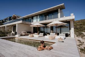 a man laying in the swimming pool of a house at Pure Sea Boutique Lodge in Gansbaai