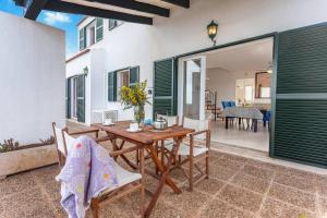 een patio met een houten tafel en stoelen bij Villa Victor - Primera linea mar, vista a puesta de sol in Cala en Blanes