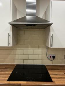 a stove top in a kitchen with white cabinets at Nice house near cricket ground in Nottingham