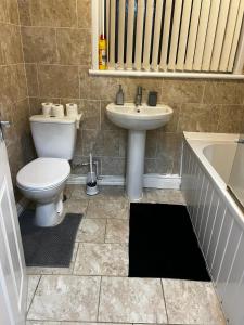 łazienka z toaletą, umywalką i wanną w obiekcie Nice house near cricket ground w Nottingham
