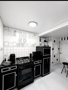 een keuken met zwarte apparatuur en een witte tegelmuur bij The 2D Spot! in Buffalo