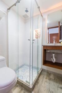a glass shower in a bathroom with a toilet at Hotel Casa Botero 102 in Bogotá