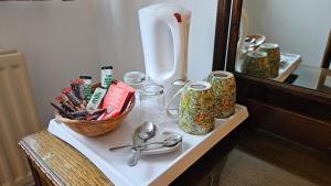 uma mesa com utensílios, um vaso e um espelho em True Lovers Knot em Blandford Forum