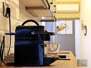 a coffee maker sitting on a counter with a glass at Avra Studio Kastoria in Kastoria