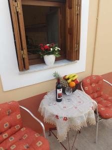 a table with a bottle of wine and a bowl of fruit at Aggeliki's House in Symi +23 photos
