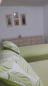 una camera da letto con un letto con cuscini verdi e bianchi di Shacks beachfront 2bdrm w/deck a Isabela